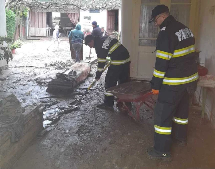 Pompierii ajută oamenii să scoată mâlul din case FOTO: ISU Caraș Severin