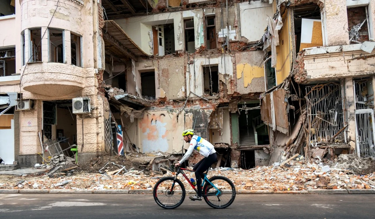 Un biciclist trece pe lângă o clădire distrusă de bombardamente în Harkov FOTO AFP
