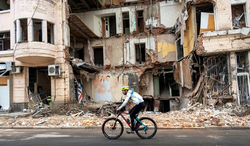 Un biciclist trece pe lângă o clădire distrusă de bombardamente în Harkov FOTO AFP