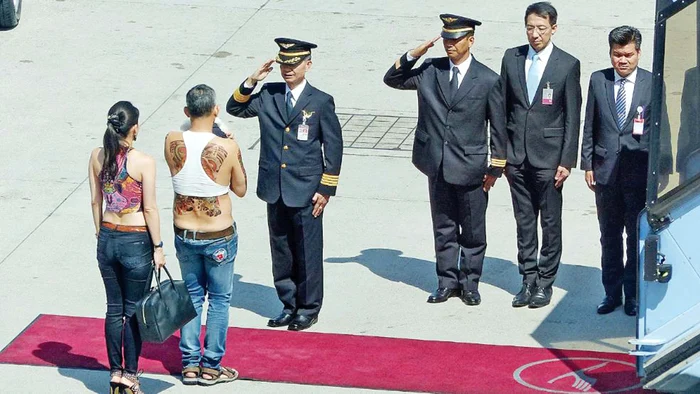 Echipajul companiei Royal Thai Airways îl salută ceremonios pe prinţul aproape gol