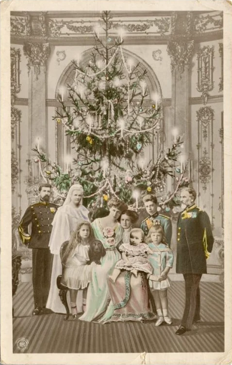 Carte poștală cu familia regală a României și bradul de Crăciun. În fotomontaj se disting regele Carol I și regina Elisabeta, principele Ferdinand și principesa Maria cu copiii lor, principii Carol și Nicolae, principesele Elisabeta, Mărioara și Ilea