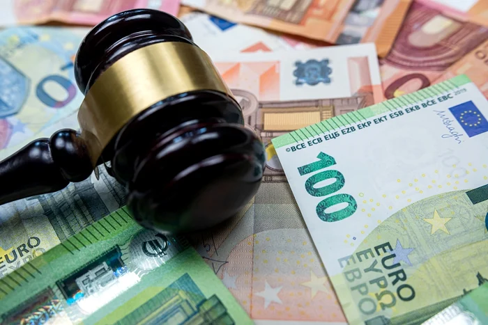 Un ciocan de judecător peste bancnote 