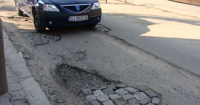 Gropile adânci de pe Strada Tudor Vladimirescu bagă maşinile în service