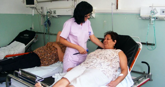neurologul Diana Ciocan examinează o pacientă internată la ATI