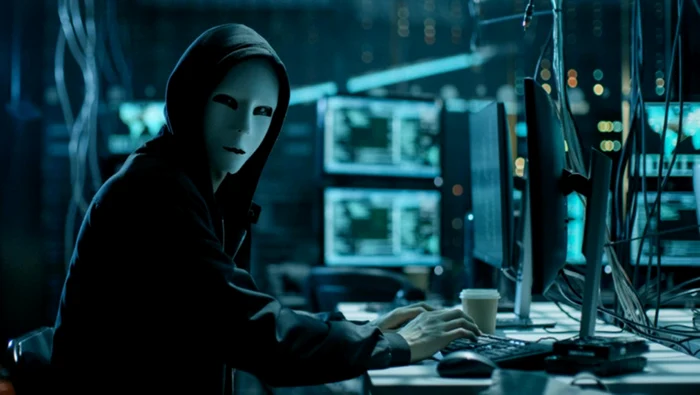 Un hacker se uită la fotograf în timp ce tastează