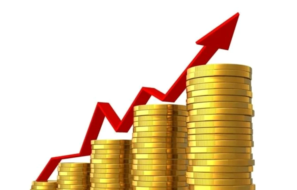 Săgeată roșie care indică o creștere economică peste fișicuri de bani așezate în ordine crescătoare