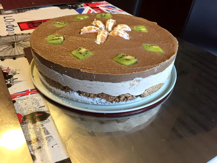 Se pune mai întâi blatul, apoi crema de cocos, apoi cea de ciocolată, iar la sfârşit se ornează cu fructe
