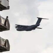 O femeie priveşte o aeronavă militară franceză A400M care trece pe deasupra ununui bloc de turn din arondismentul 11 în timpul unei repetiţii pentru sărbătoarea de Ziua Naţională în Paris Franţa FOTO EPA-EFE / Etienne Laurent