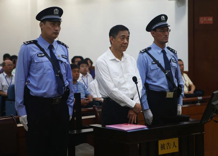 Bo Xilai, păzit de-o parte şi de alta de poliţişti, în timpul citirii verdictului. FOTO: Reuters