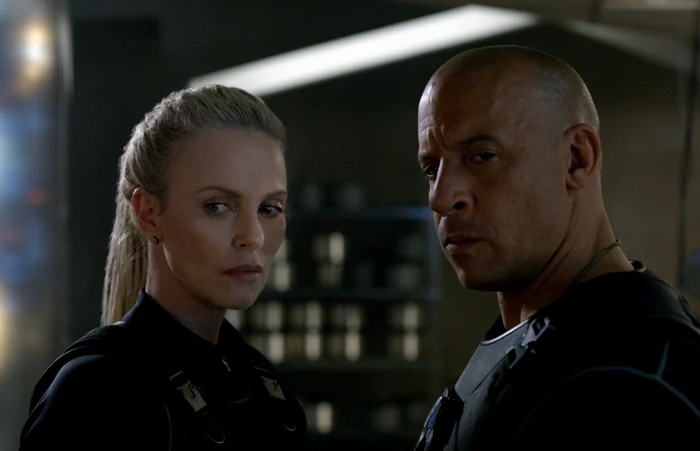 În noul film al seriei, o femeie misterioasă, Chiper (Charlize Theron) îl convinge pe Dom (Vin Diesel) să se alăture lumii interlop FOTO cinemagia.ro