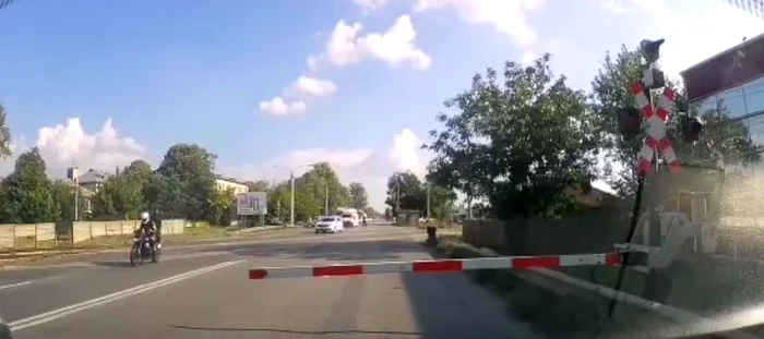 Motociclistul a trecut peste calea ferată, ignorând barierele FOTO captură video 