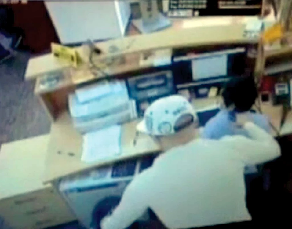 0:29. Cu mâna dreapă, ţine pistolul  la capul femeii, iar  cu stânga scoate  banii din sertar