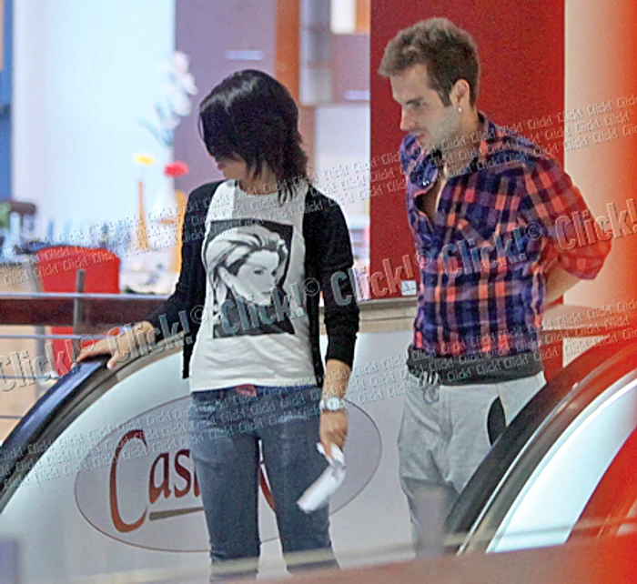 Cei doi coboară pe scara rulantă şi stau destul de mult în incinta centrului comercial