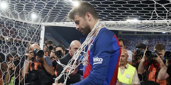 Jucătorul echipei FC Barcelona Gerard Pique taie plasa după ce echipa sa a câştigat finala Cupei Regelui dintre Barcelona şi Deportivo Alaves desfăşurat pe stadionul Vicente Calderon din Madrid. FOTO EPA