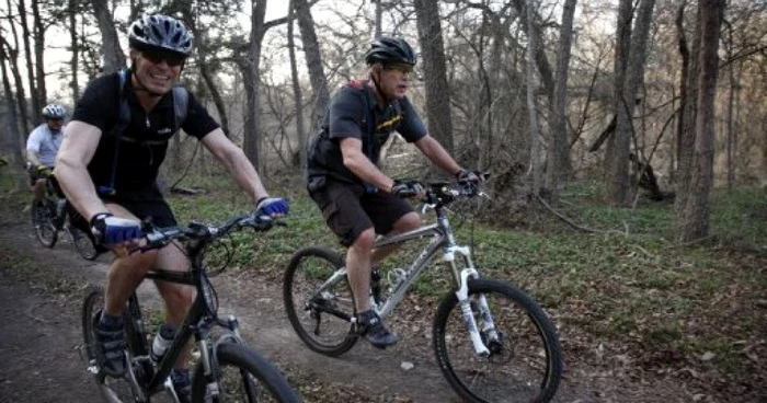 Anders Fogh Rasmussen (stânga) şi fostul lider al SUA, George W. Bush, cu bicicleta; sursa: AFP