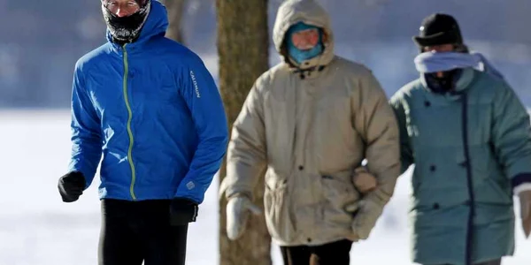 Un barbat trece in alergare pe lang un cuplu in varsta pe marginea lacului Harriet in Minneapolis Statele Unite FOTO Reuters