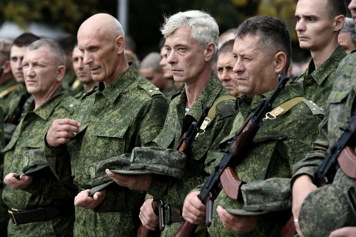 Mai mulți bărbați ruși, aliniați la un centru de mobilizare pentru războiul din Ucraina