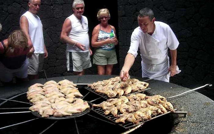 Angajaţii restaurantului „El Diabolo/Diavolul“ din Lanzarote, Insulele Canare (Spania) frig carnea comandată de clienţi pe un grătar aflat deasupra unui vulcan inactiv. FOTO Arhiva Adevărul