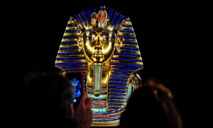 Un turist fotografiază o replică a măștii lui Tutankhamon, prezentată la „Tutankhamon. Expoziția”, Madrid, noiembrie 2019 (foto: Getty Images)