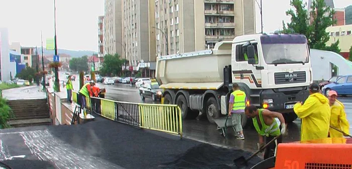 Muncitorii aveau pelerine de ploaia, dar asfaltau de zor FOTO CRISTIAN FRANŢ