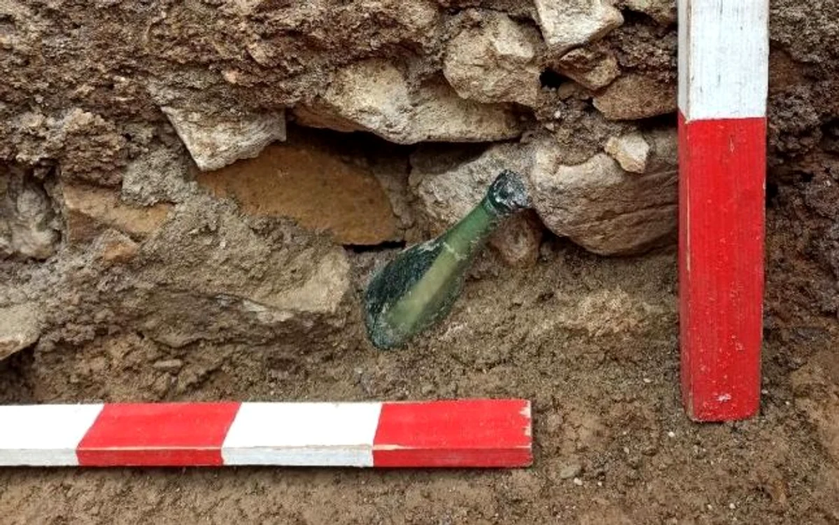 O sticlă cu un răvaş de hârtie a fost descoperită de arheologii care efectuau săpături în primul cimitir al Mănăstirii Văratec din NeamţFoto: adevarul.ro