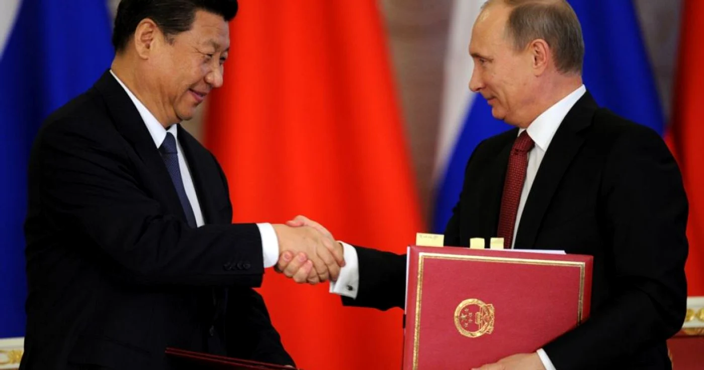 Xi Jinping (dreapta) și Vladimir Putin (stânga) dând mâna