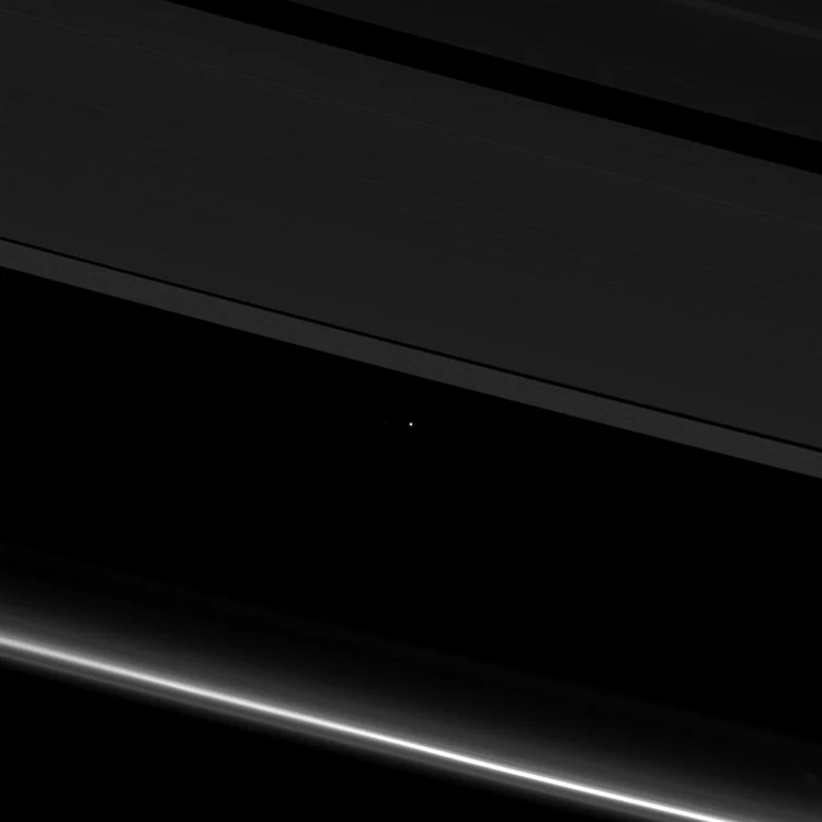terra pamant vazut printre inelele lui satrun de cassini foto nasa