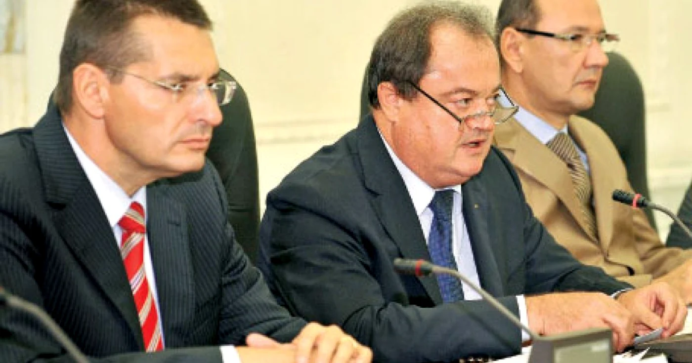 Chestorul Petre Tobă (stânga) şi secretarul de stat Dan Fătuloiu (dreapta) îl încadrează pe fostul ministru de Interne Vasile Blaga