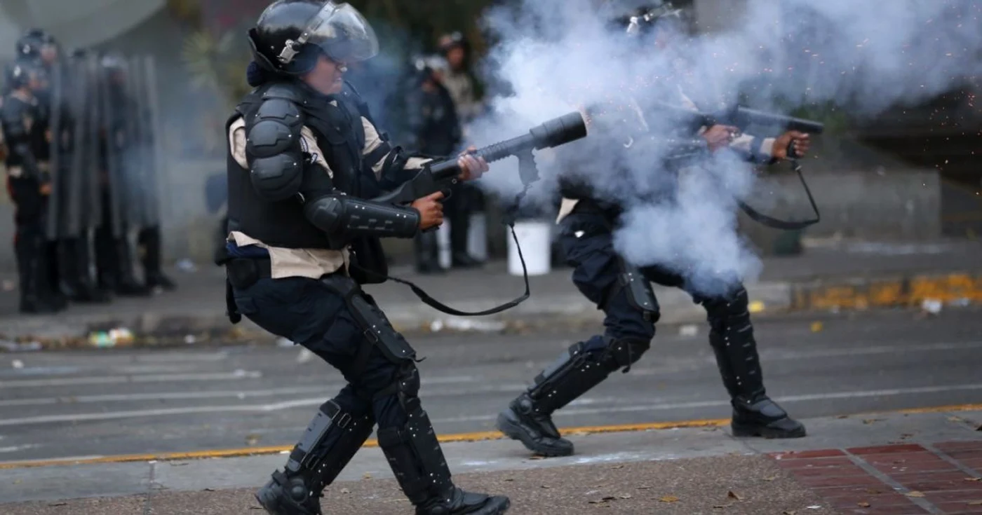 Membri ai forţelor de ordine răspund protestatarilor, la Caracas FOTO EPA
