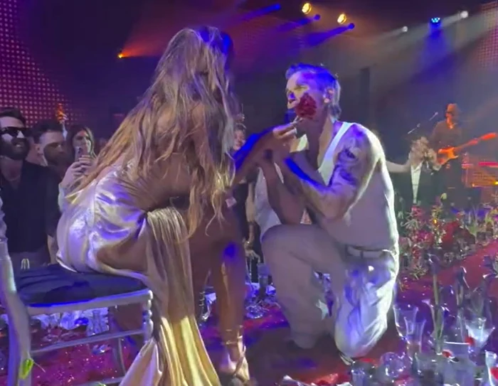 VIDEO Robbie Williams, în genunchi în fața Mădălinei Ghenea. S-a urcat pe masă ca să cânte pentru ea