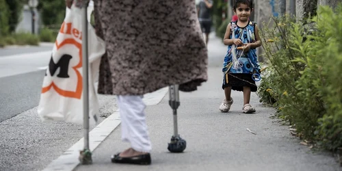 O femeie de 75 de ani din Kabul Afganistan merge pe stradă cu nepoata în faţa unei tabere de refugiaţi în Innsbruck Austria FOTO Guliver/GettyImages