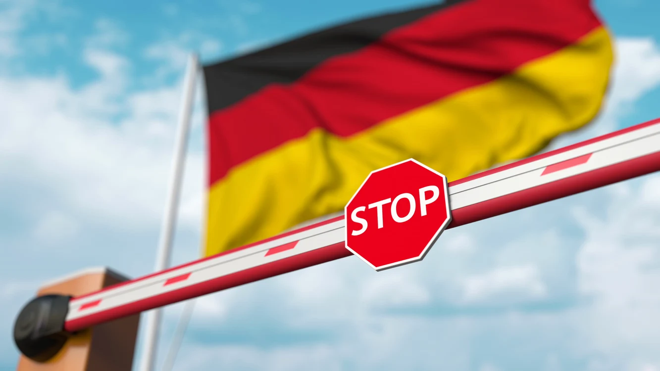 foto stea germania și barieră cu semnuș „STOP”