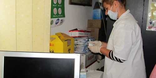 Asistenta pregătea o doză de vaccin pentru un coleg