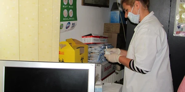 Asistenta pregătea o doză de vaccin pentru un coleg