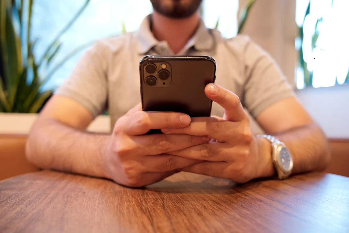 Un bărbat se uită la lupte MMA pe telefon