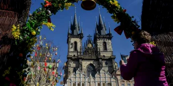 O femeie face poze în vizita sa la piaţa tradiţională de Paşte din Piaţa Oraşului Vechi în faţa Bisericii Maicii Domnului în Praga Cehia FOTO AFP / Michal Cizek