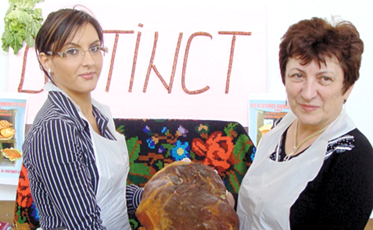 Dorina Gavriluţ (dreapta) ţine în sare piciorul de porc, după care îl afumă la rece