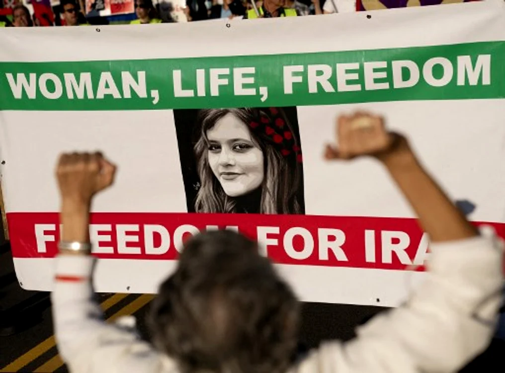 Sloganul „Femeie, Viață, Libertate“ și portretul lui Mashra Amini, pe un banner 