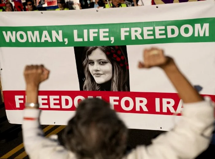 Sloganul „Femeie, Viață, Libertate“ și portretul lui Mashra Amini, pe un banner