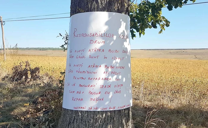 
    Aşa arată blestemul scris de săteni şi afişat pe marginea drumului  