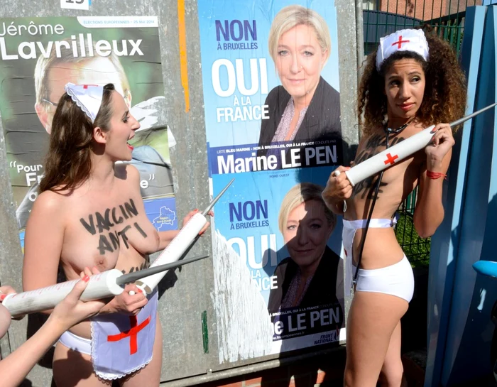 Membrele Femen în faţa unui afiş cu imaginea lui Marine Le Pen FOTO Le Figaro