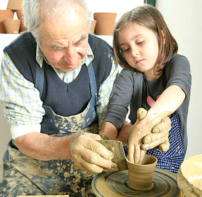 Nea Mitică, meşterul olar, îi învaţă pe cei mici să facă oale şi figurine din lut