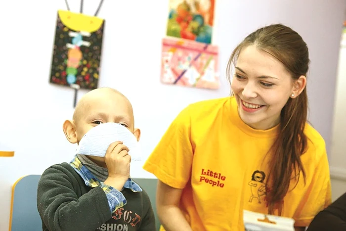 Vanea (4 ani), mândru de scoica pe care a confecţionat-o cu ajutorul voluntarei Doina Goiman Foto: Dumitru Goncear