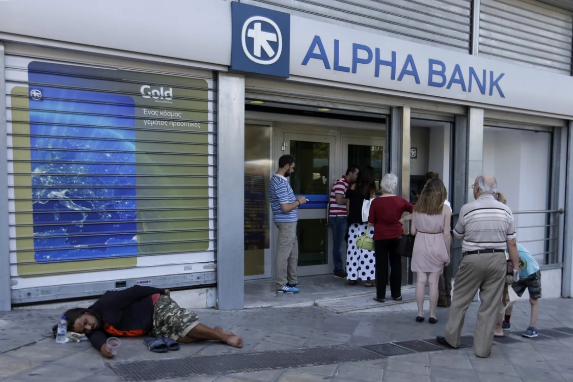 Persoane care stau la coadă la bancomate pentru  a-şi retrage cei 60 de euro la care au dreptul. FOTO AP