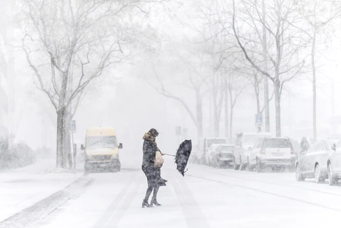 O femeie traversează o stradă sub viscol la Zurich Elveţia FOTO EPA-EFE / Ennio Leanza