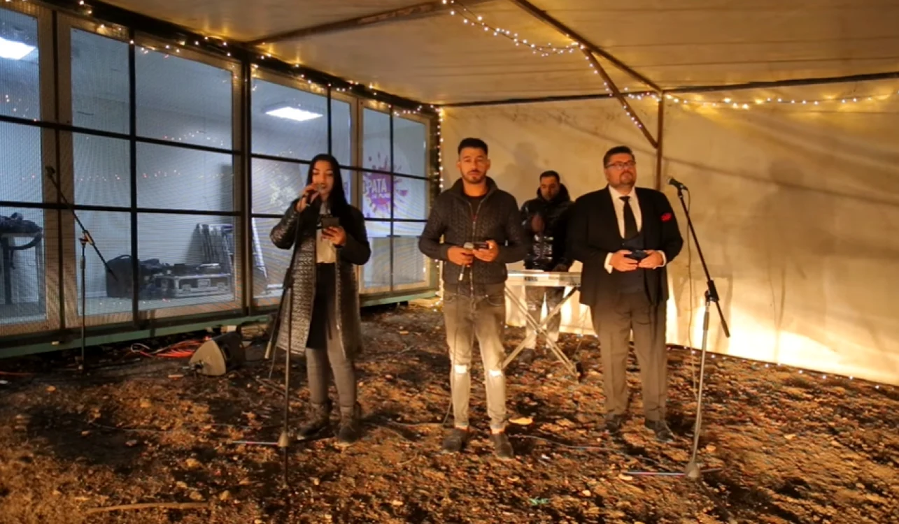 Casandra Unica, Farid de la Cluj, şi tenorul Florin Pop au interpretat colinda pe o scenă improvizată în apropierea rampei de gunoi. FOTO: Captură video/Pata Radio