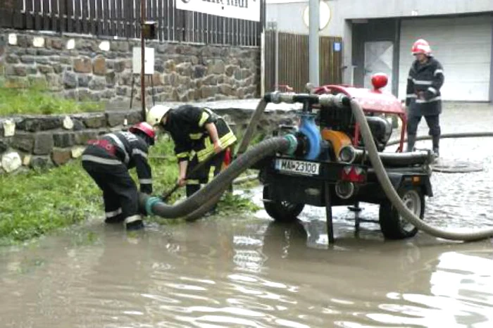 
    Pompierii scot apa cu motopompele  