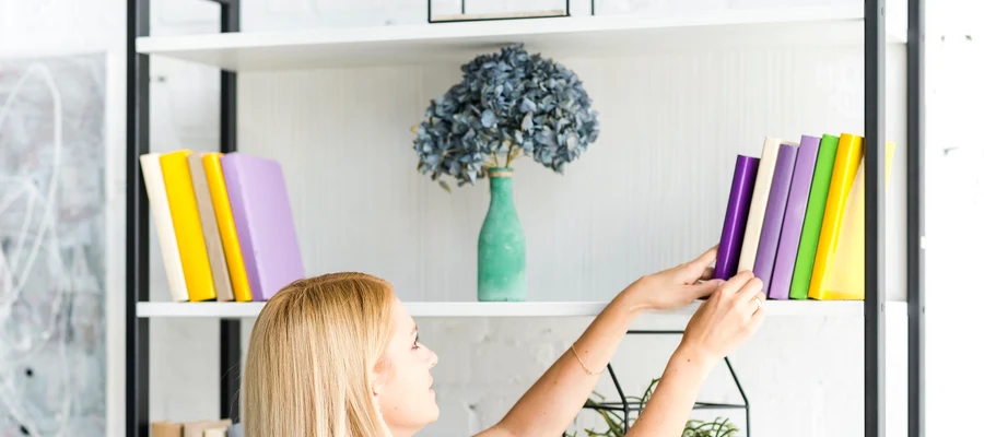 woman choosing book from shelf home jpg