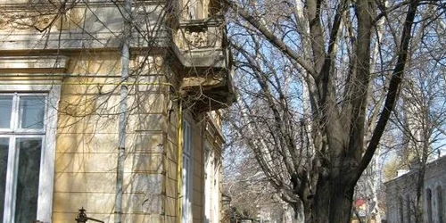 De sub balconele clădirilor vechi cad bucăţi de tencuială