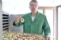 Gospodarul aşază merele tăiate în cuptorul pe lemne jpeg